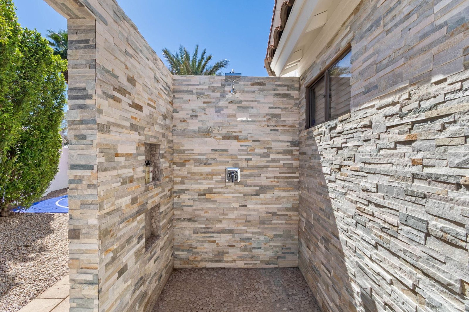 Outdoor shower finished in stacked stone veneer