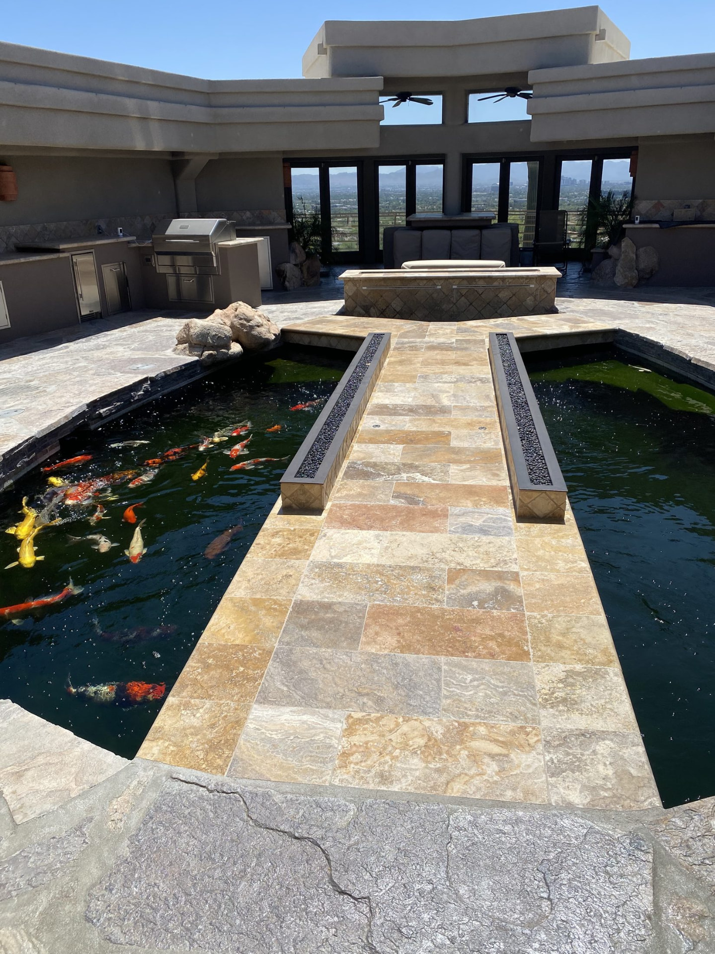 Wide view of the outdoor kitchen, fire table and both koi ponds