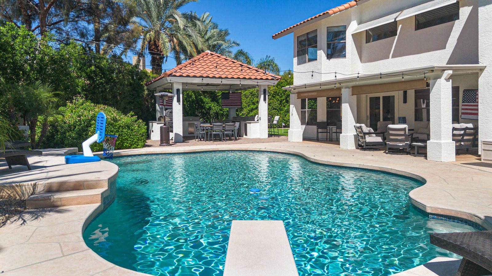 Swimming pool with diving board beside a new tile-roof shade pavilion