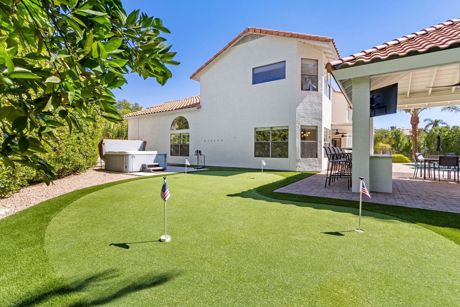 Artificial turf putting green with chipping area in the remodeled backyard
