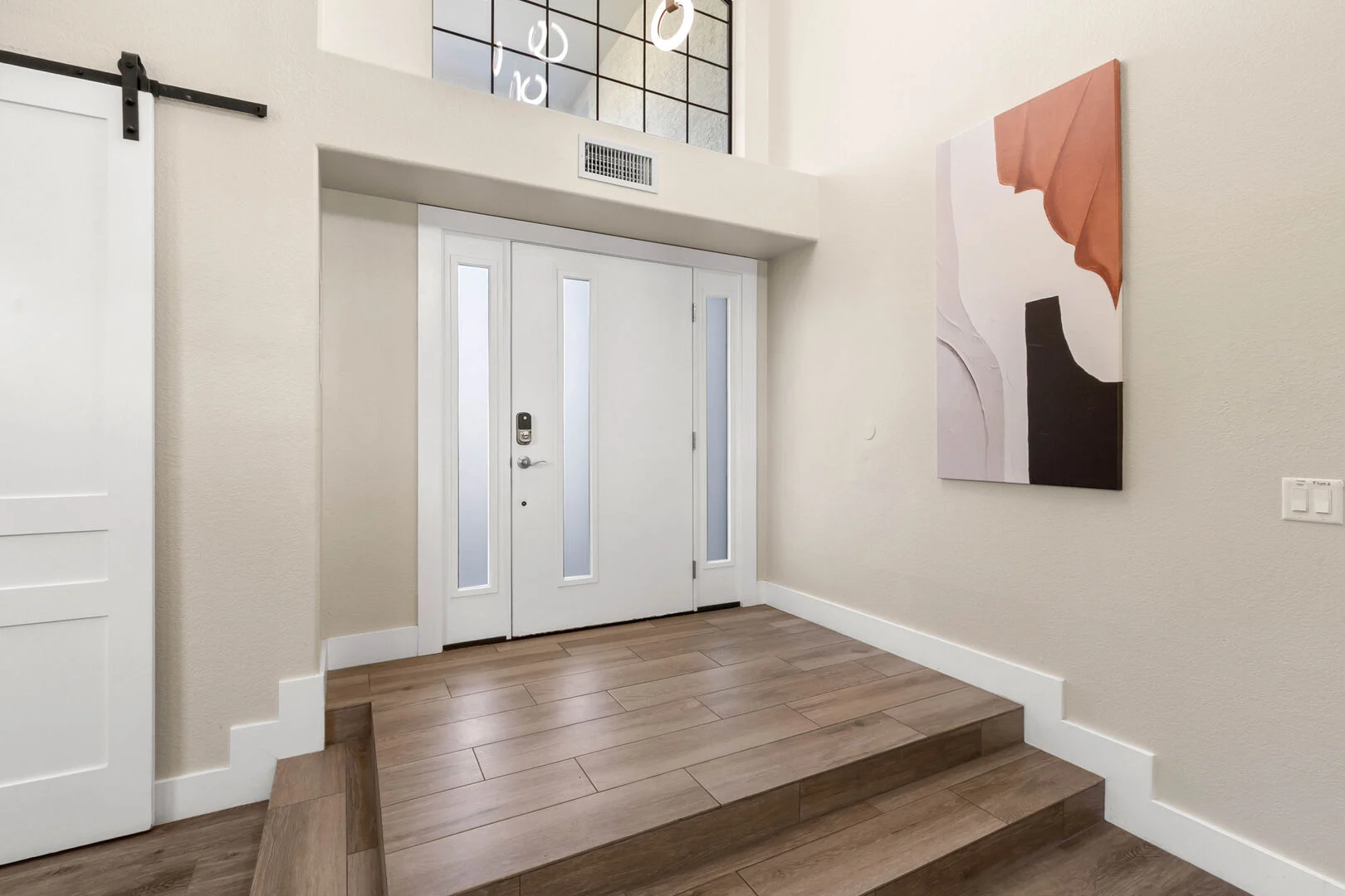 Bright front entry with tiled steps, new interior doors and barn door
