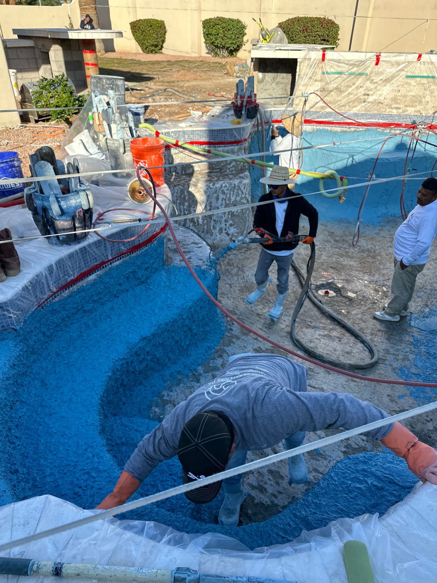 Crew applying the blue interior surface to the rebuilt pool