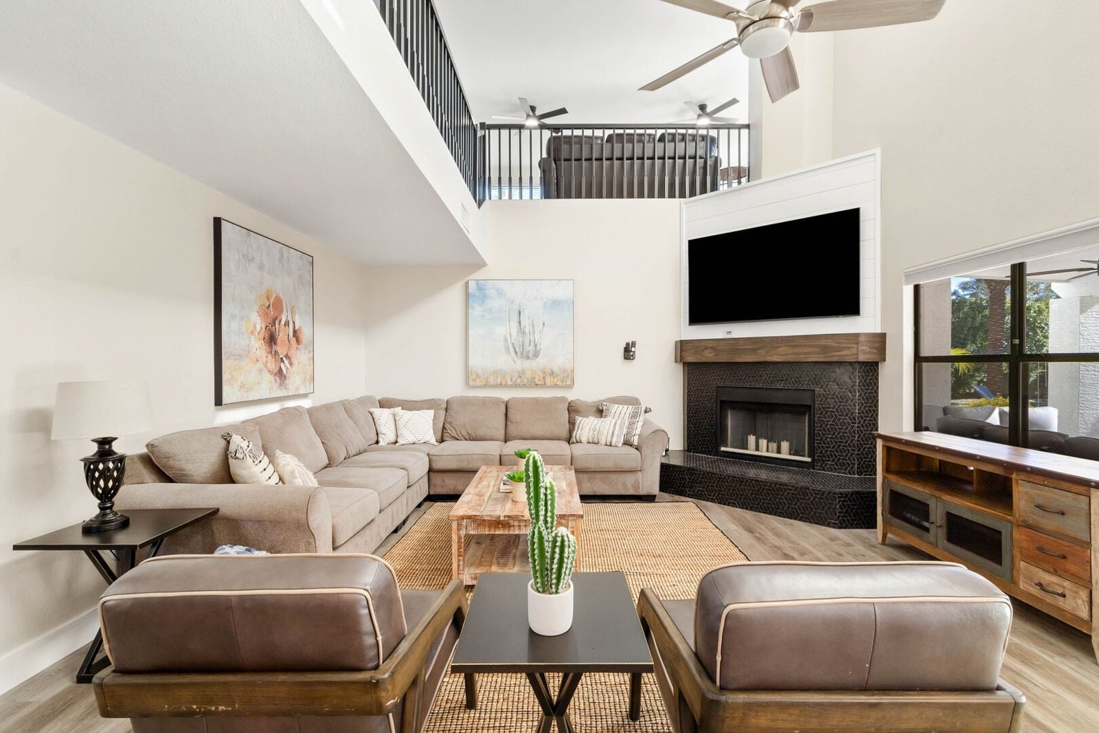 Great room with sectional seating, refaced stone fireplace and open loft above