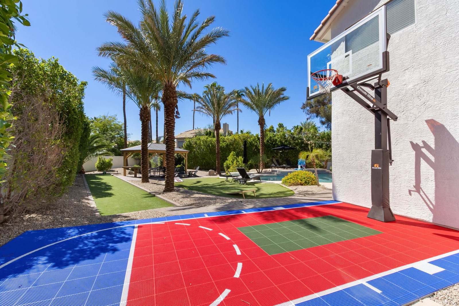 Backyard basketball sport court with painted surface and hoop