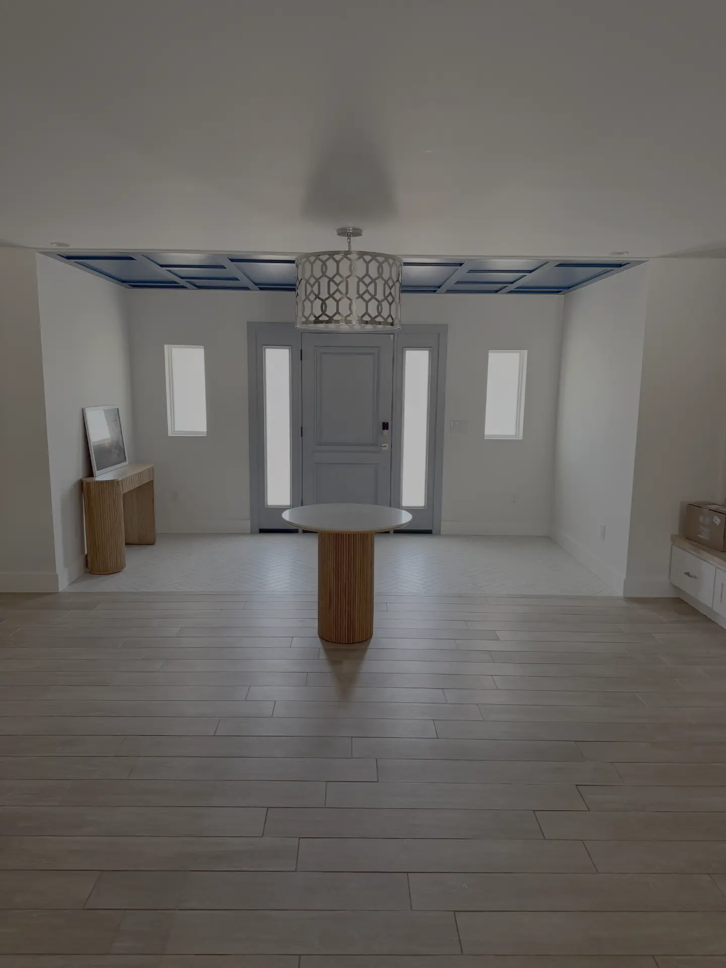 Reworked entry interior with a coffered ceiling and herringbone tile floor