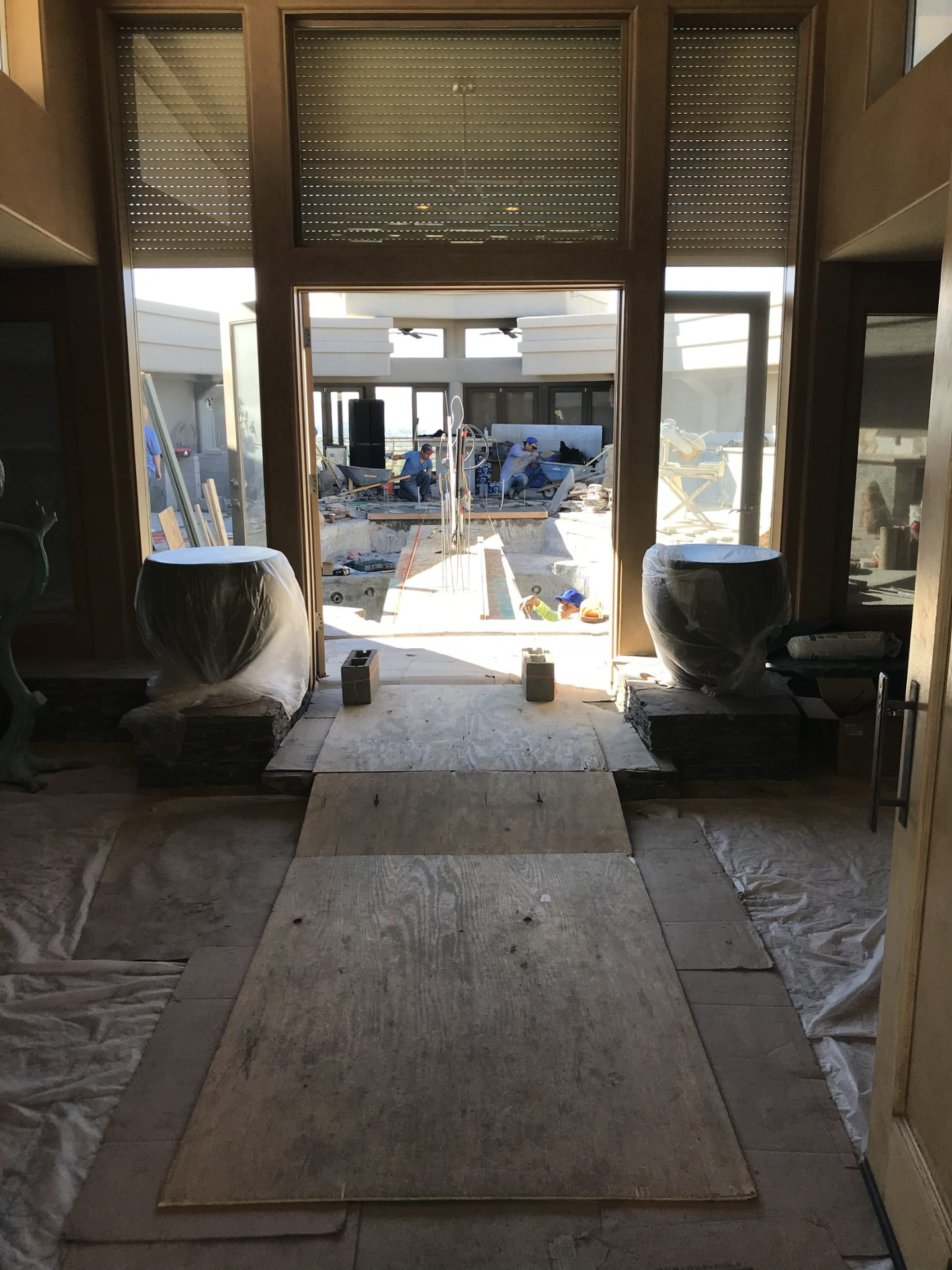 View from inside the home through open doors to the pond channel being tiled