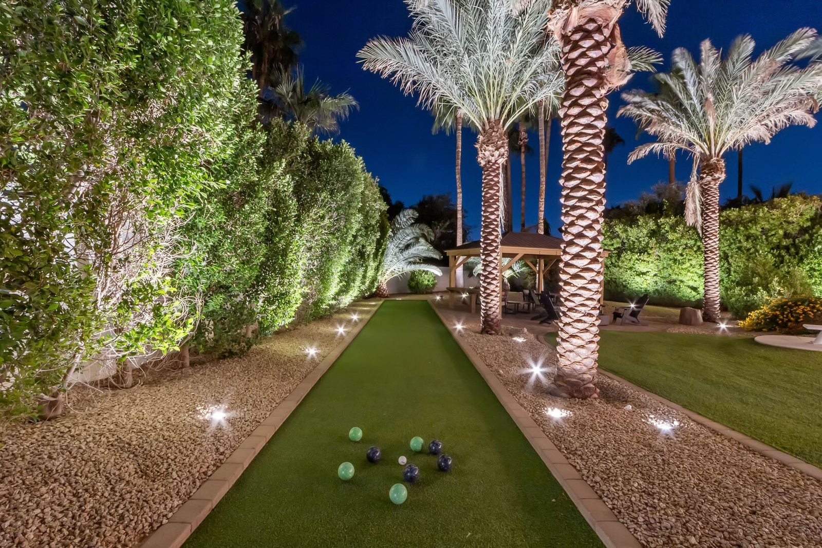 Bocce ball court lit by landscape lighting at night