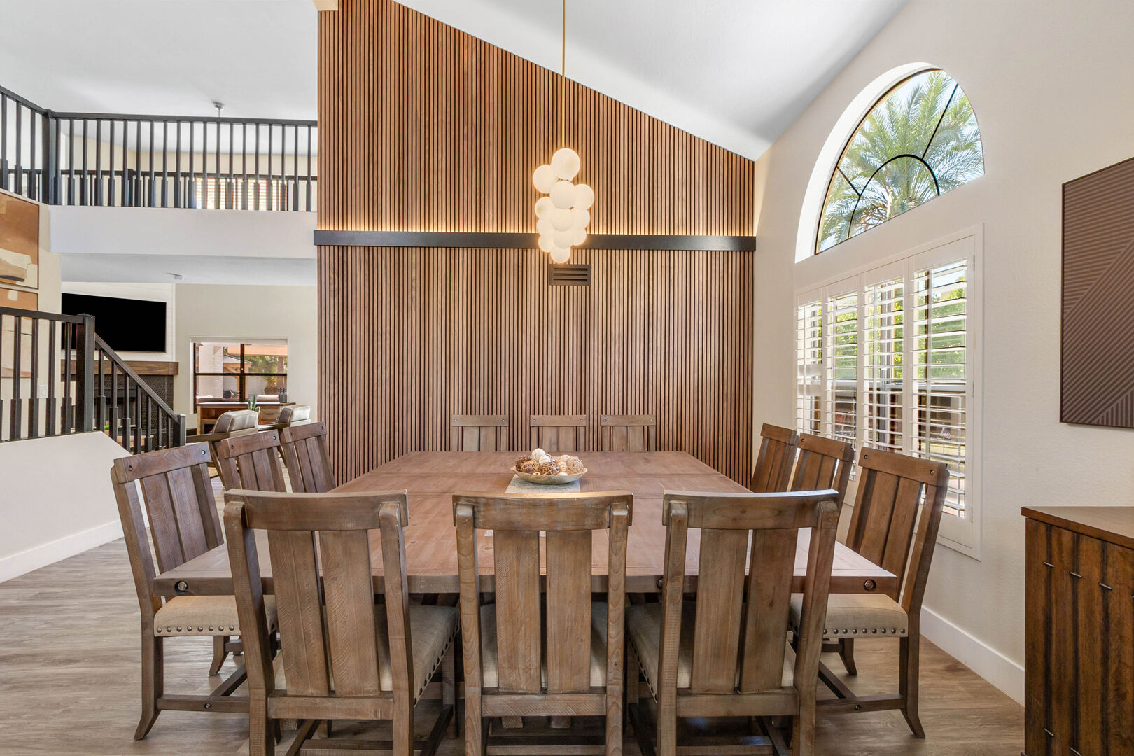 Dining room with vaulted ceiling, full-height wood slat feature wall and large dining table