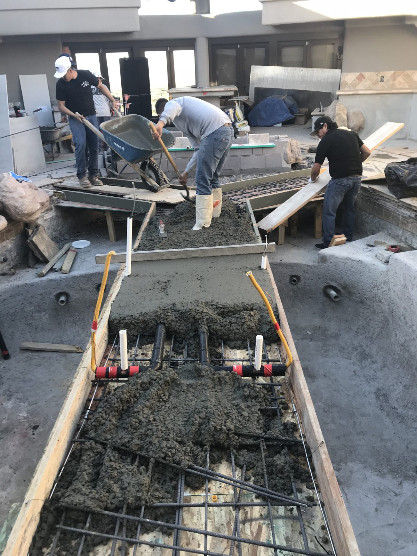 Freshly poured concrete walkway dividing the two pond basins