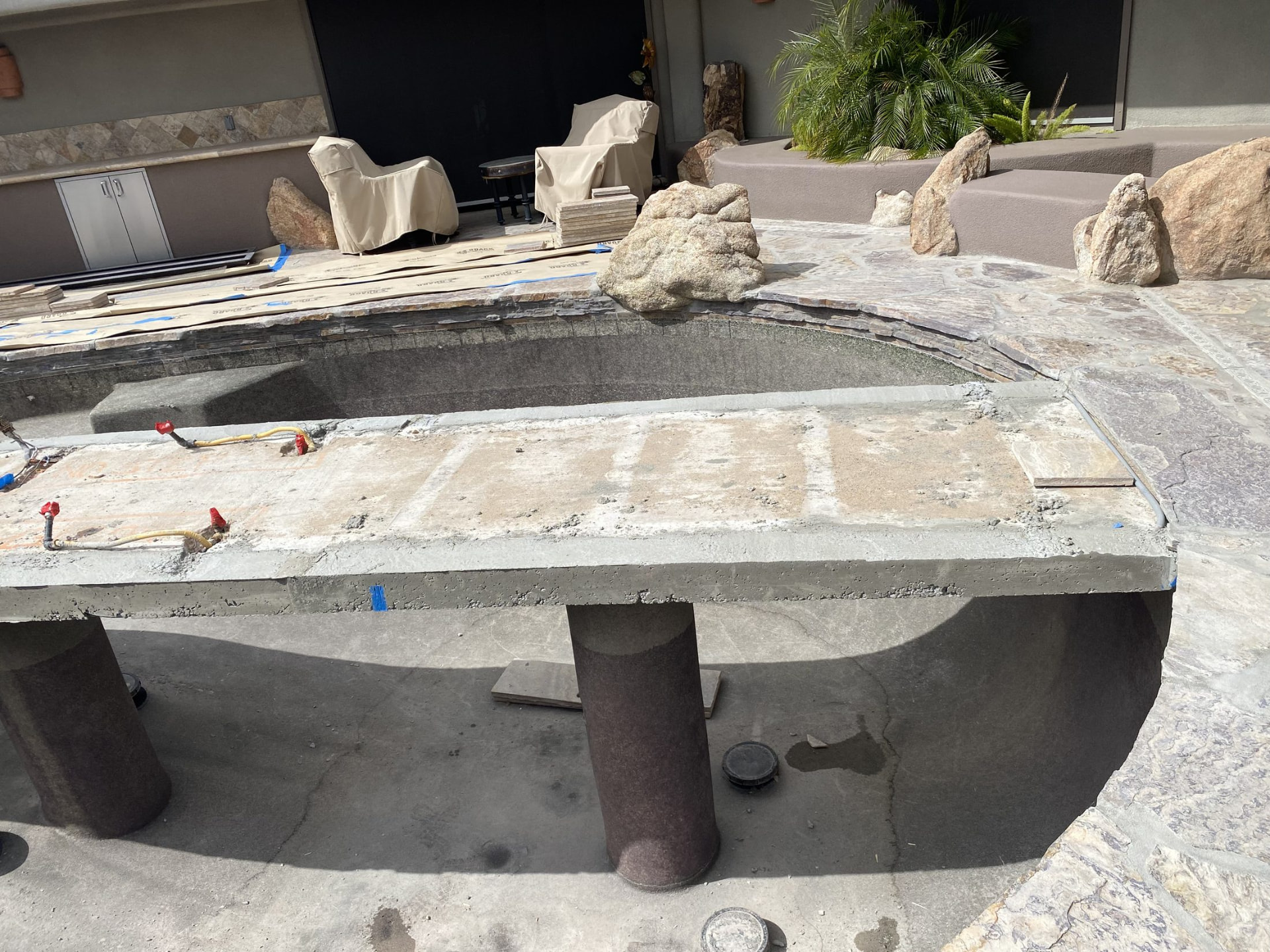 Granite boulders placed around the pond before the travertine cap is installed